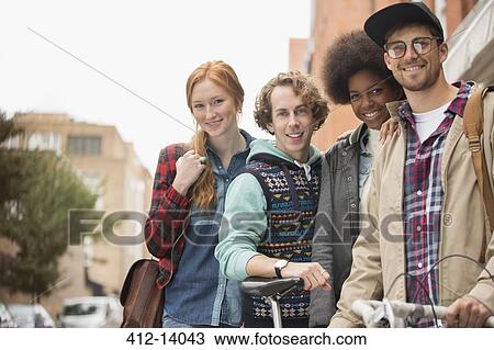 Stock Image - Friends smiling together on city street. Fotosearch