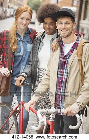 Friends smiling together on city street View Large Photo Image Stock Photo - Friends smiling together on city street. Fotosearch