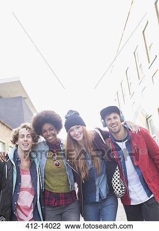 Stock Image - Friends standing together on city street. Fotosearch