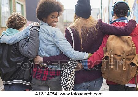 Picture - Friends walking together on city street. Fotosearch