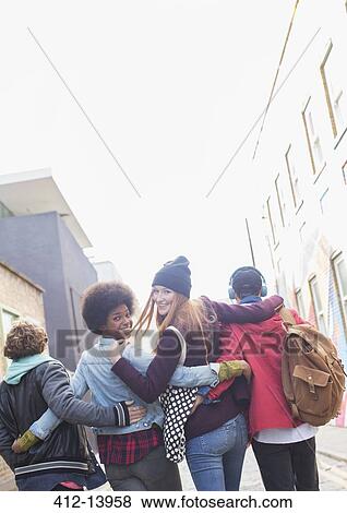 Stock Photo - Friends walking together on city street. Fotosearch