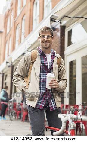 Stock Image - Man drinking coffee on city street. Fotosearch