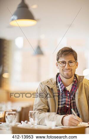 Man making notes in cafe View Large Photo Image Stock Image - Man making notes in cafe. Fotosearch