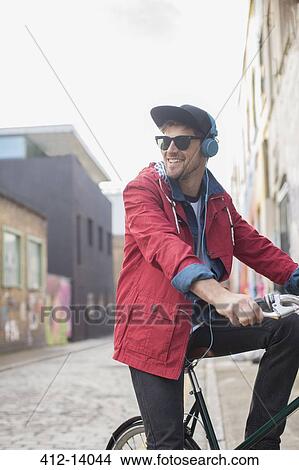 Picture - Man riding bicycle on city street. Fotosearch
