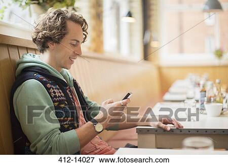 Man using cell phone in cafe View Large Photo Image Stock Photo - Man using cell phone in cafe. Fotosearch