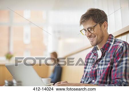 Picture - Man using laptop in cafe. Fotosearch
