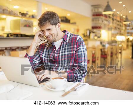 Man using laptop in cafe View Large Photo Image Stock Image - Man using laptop in cafe. Fotosearch