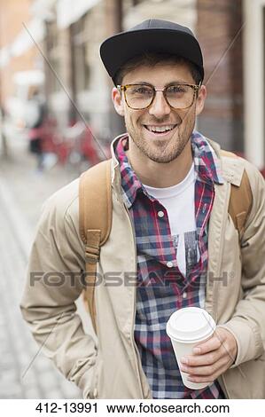 Stock Image - Man with cup of coffee on city street. Fotosearch