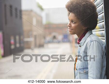 Stock Image - Pensive woman standing on city street. Fotosearch