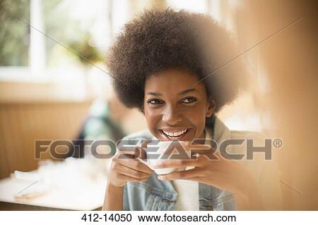 Stock Image - Woman drinking coffee in cafe. Fotosearch