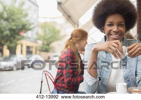 Woman drinking cup of coffee at sidewalk cafe View Large Photo Image Stock Image - Woman drinking cup of coffee at sidewalk cafe. Fotosearch