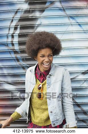 Woman laughing in front of graffiti wall View Large Photo Image Stock Photography - Woman laughing in front of graffiti wall. Fotosearch