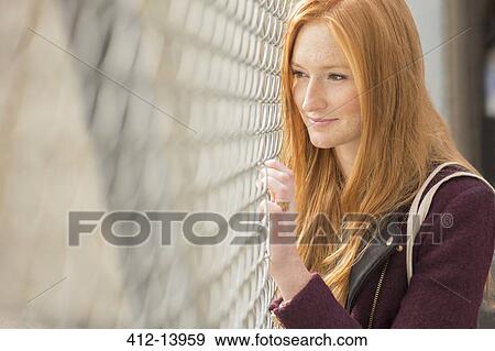 Woman peering through chain link fence View Large Photo Image Stock Photo - Woman peering through chain link fence. Fotosearch