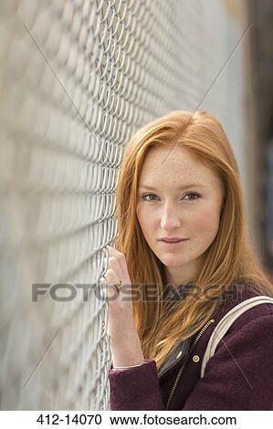 Woman standing at chain link fence View Large Photo Image Stock Image - Woman standing at chain link fence. Fotosearch