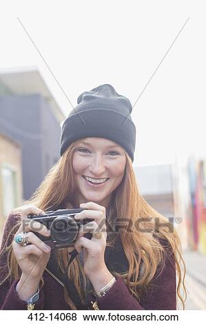 Woman using camera on city street View Large Photo Image Stock Photo - Woman using camera on city street. Fotosearch