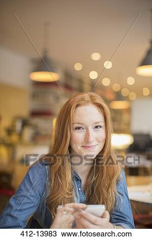 Stock Image - Woman using cell phone in cafe. Fotosearch