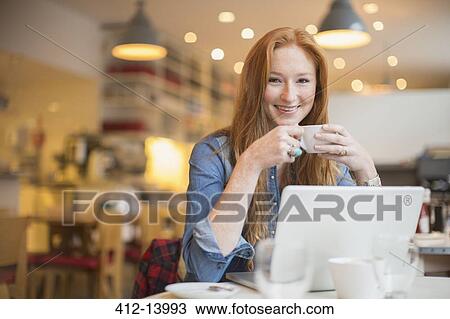 Woman using laptop in cafe View Large Photo Image Stock Image - Woman using laptop in cafe. Fotosearch