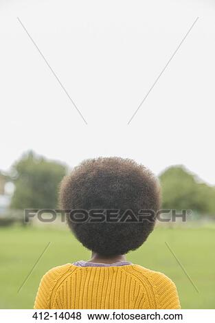 Stock Photo - Woman with afro standing in park. Fotosearch