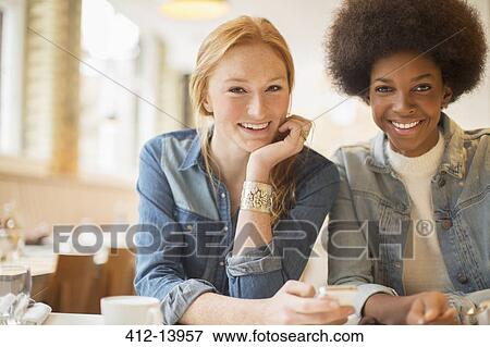 Women enjoying coffee together in cafe View Large Photo Image Stock Photo - Women enjoying coffee together in cafe. Fotosearch