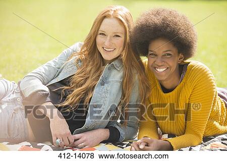 Stock Photo - Women relaxing together in park. Fotosearch