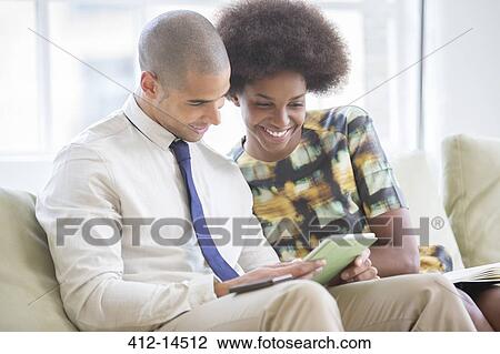 Business people using digital tablet on sofa View Large Photo Image Stock Image - Business people using digital tablet on sofa. Fotosearch