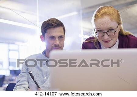 Stock Photo - Business people using laptop in office. Fotosearch