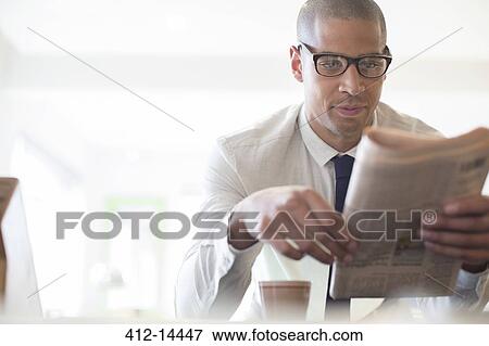 Stock Photo - Businessman reading newspaper at breakfast. Fotosearch