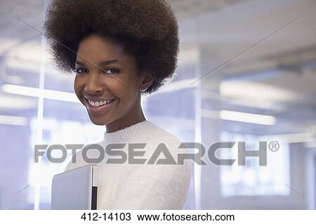 Stock Image - Businesswoman smiling in office. Fotosearch