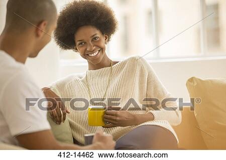 Couple drinking coffee on sofa View Large Photo Image Stock Image - Couple drinking coffee on sofa. Fotosearch