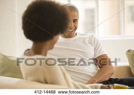 Couple relaxing together on sofa View Large Photo Image Stock Photo - Couple relaxing together on sofa. Fotosearch