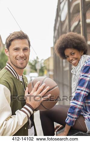 Stock Image - Couple smiling together on city street. Fotosearch