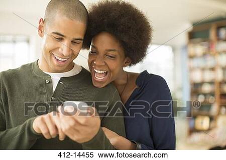 Stock Photography - Couple using cell phone together. Fotosearch