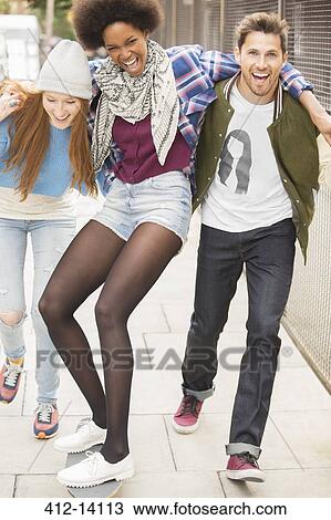 Friends laughing on city street View Large Photo Image Stock Image - Friends laughing on city street. Fotosearch