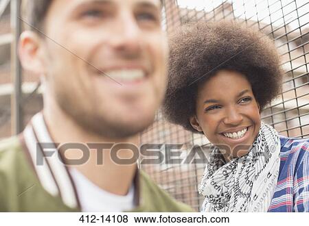Man and woman smiling near fence View Large Photo Image Stock Photo - Man and woman smiling near fence. Fotosearch