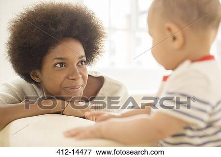 Mother and baby boy playing on sofa View Large Photo Image Stock Photo - Mother and baby boy playing on sofa. Fotosearch