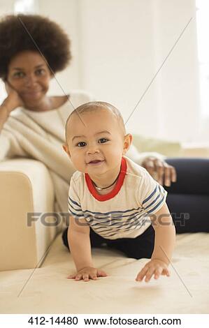 Stock Image - Mother and baby boy relaxing on sofa. Fotosearch