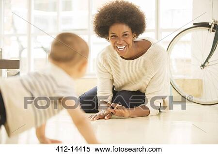 Mother and baby son playing on living room floor View Large Photo Image Stock Photography - Mother and baby son playing on living room floor. Fotosearch