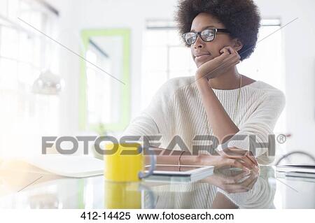Pensive woman using digital tablet at table View Large Photo Image Stock Photography - Pensive woman using digital tablet at table. Fotosearch