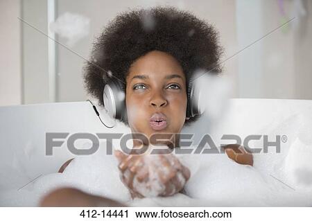 Woman listening to headphones in bath View Large Photo Image Stock Image - Woman listening to headphones in bath. Fotosearch