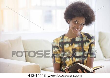 Stock Image - Woman reading on sofa. Fotosearch