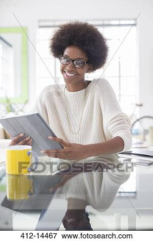 Stock Photo - Woman using digital tablet at table. Fotosearch