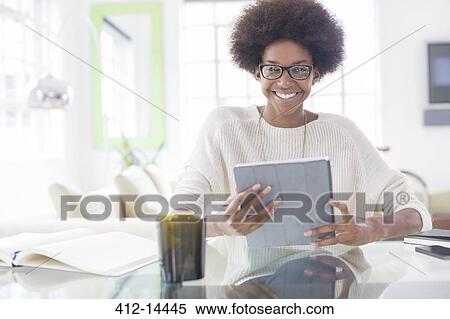 Stock Photography - Woman using digital tablet at table. Fotosearch