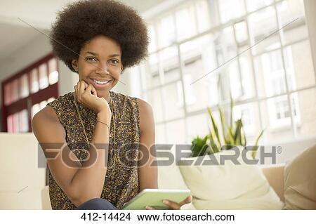 Woman using digital tablet on sofa View Large Photo Image Picture - Woman using digital tablet on sofa. Fotosearch