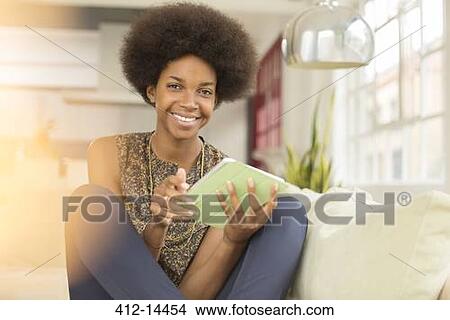 Woman using digital tablet on sofa View Large Photo Image Picture - Woman using digital tablet on sofa. Fotosearch