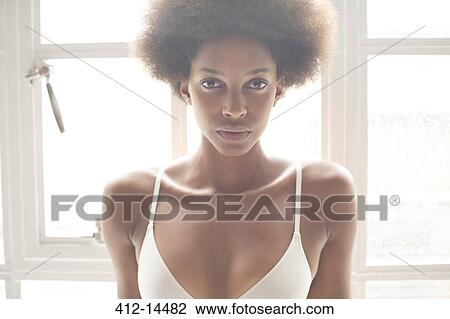 Woman wearing bra in front of window View Large Photo Image Stock Image - Woman wearing bra in front of window. Fotosearch