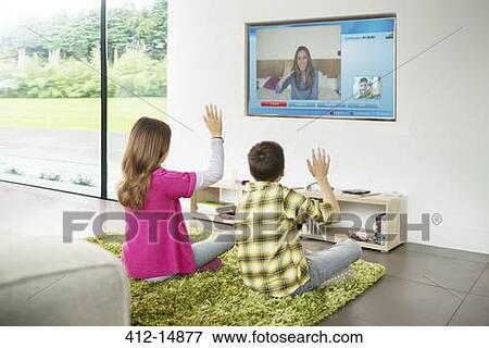 Children video chatting on television in living room View Large Photo Image Stock Photo - Children video chatting on television in living room. Fotosearch