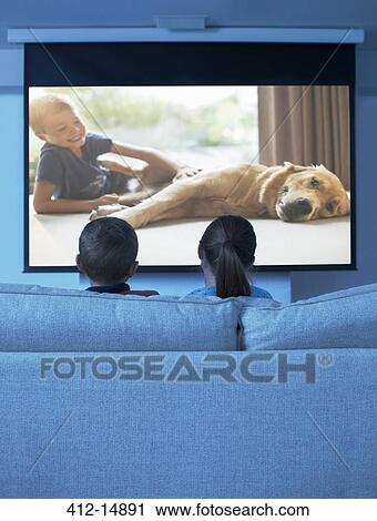 Stock Image - Children watching television in living room. Fotosearch