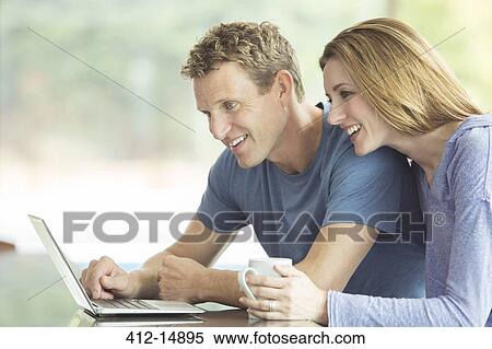 Stock Photography - Couple using laptop together. Fotosearch