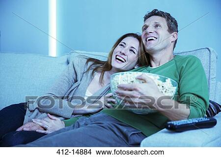 Couple watching television on sofa View Large Photo Image Picture - Couple watching television on sofa. Fotosearch