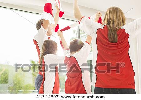 Family in sports jerseys cheering together View Large Photo Image Stock Photo - Family in sports jerseys cheering together. Fotosearch